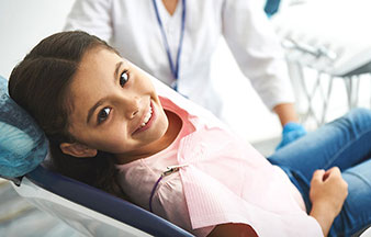 young girl smiling from dental chair
