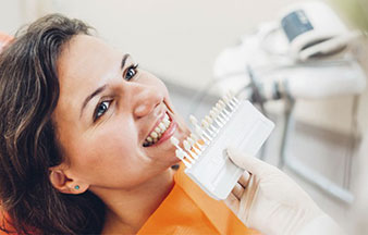 woman smiling while teeth are compared for whitening